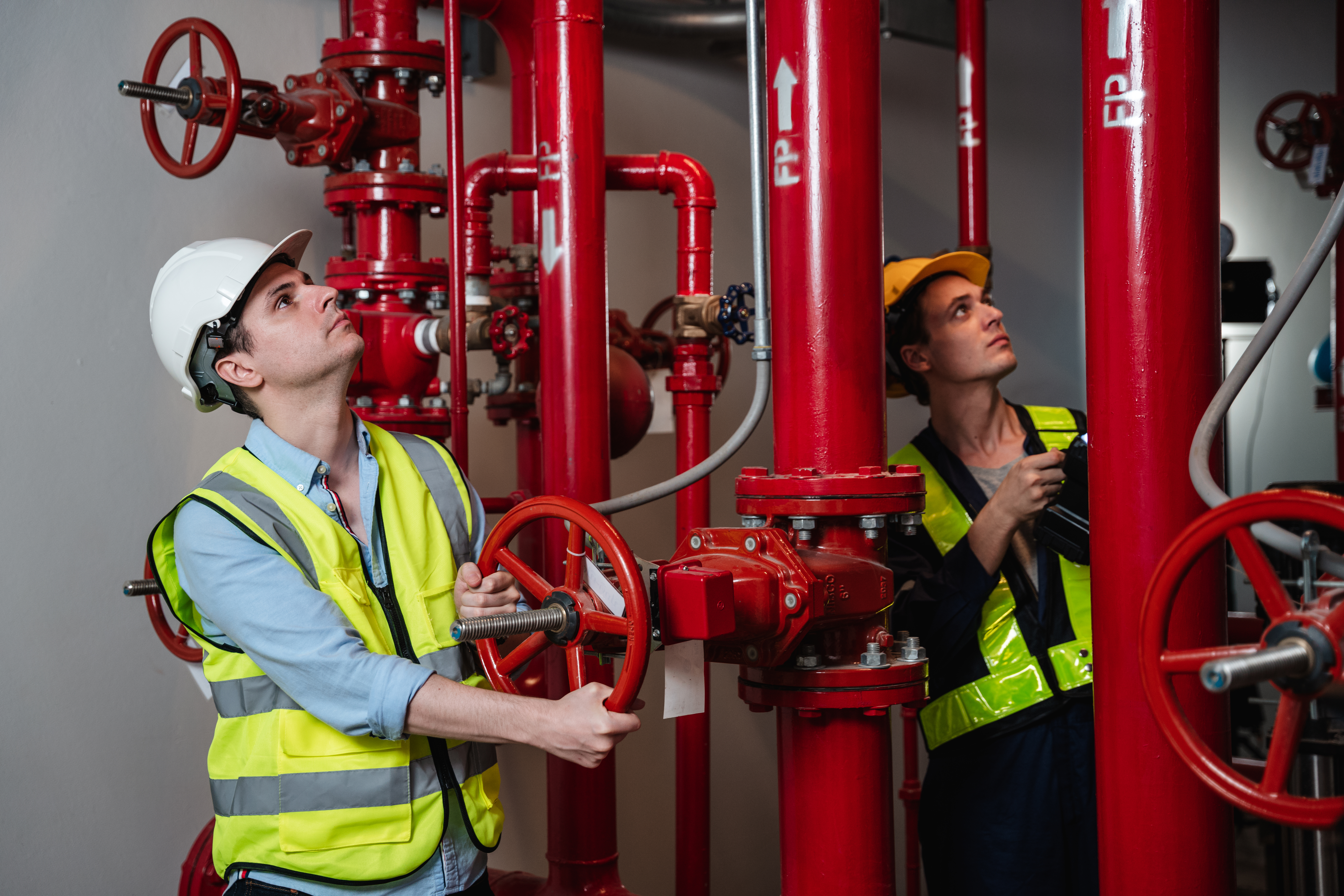 Engineers inspecting the inside plumbing and water valves of an industrial facility